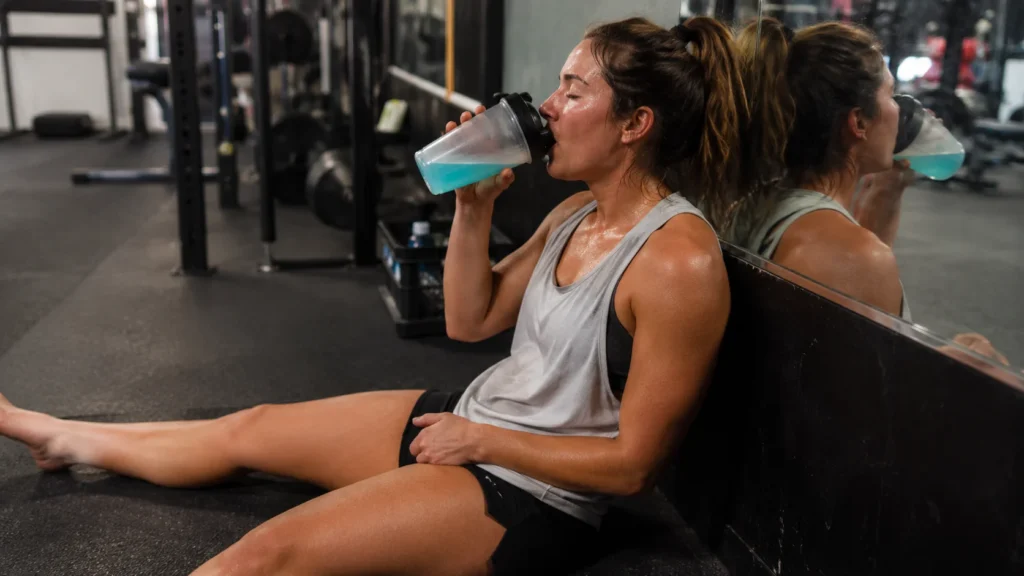 Athlete drinking electrolyte drink after gym workout for post-exercise hydration and recovery
